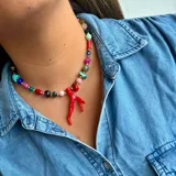 Collar corto de cuentas de colores con dije de coral rojo.