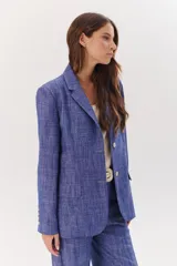 Blazer de lino color coral, con solapas de muesca, cierre con dos botones y bolsillos delanteros con solapa.