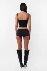 Corset negro con breteles finos regulables, escote recto y ballenas en el delantero.