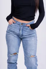 Jeans mom fit celeste claro con roturas en las rodillas.