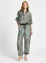 Pantalón de tiro alto confeccionado en tejido similar al lino con estampado animal, cintura elástica con cordón, cuatro bolsillos, banda lateral, bajos ajustables y acabado pespunteado.