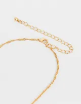 Cadena dorada con dije de strass y corazón de metal.