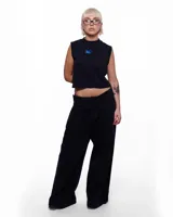 Pantalón de denim negro con corte sastrero de pierna ancha, tiro alto y pretina cruzada. Presenta un aplique de caballo/dragón en bronce hecho a mano y bordado del logo Temblad en la parte trasera.