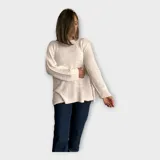 Sweater tejido color crudo, con escote redondo y hebra en relieve con brillo.