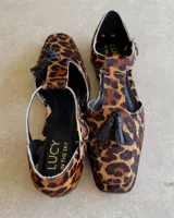 Mocasín de cuero vacuno color verde oscuro, con tira sobre el empeine y hebilla dorada.