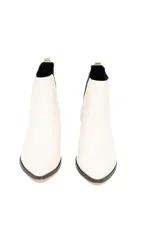 Botín Chelsea de cuero liso color blanco con elásticos laterales negros, taco bajo cuadrado y suela de goma antideslizante.