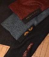 Chaqueta corta de terciopelo azul marino con cuello mao, mangas abullonadas, cierre frontal con botones dorados y bordados florales con cuentas azules.