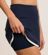 Short pollera deportivo de microfibra azul marino con bajo contrastante en blanco.