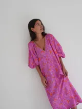 Vestido midi de corte holgado con estampado floral en tonos rosa y naranja, escote en V y mangas cortas amplias.