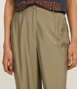 Pantalón de viscosa color beige, de corte recto, con bolsillos laterales y cierre de botón y cremallera.