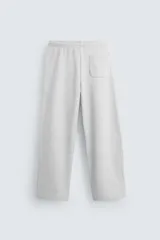 Pantalón jogger negro de corte ancho, confeccionado en tejido de algodón con interior de rizo. Cuenta con cintura elástica ajustable con cordón interior, bolsillos laterales y bolsillo trasero de parche.