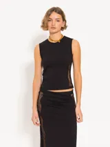 Top negro de punto con calce al cuerpo y cuello redondo. Presenta recortes laterales de encaje y logo JCH bordado en el lateral.