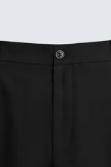 Pantalón negro relaxed fit confeccionado en tejido con algodón, lino y lyocell. Cintura con detalle de pliegues frontales dobles, bolsillos delanteros y traseros. Cierre frontal con cremallera y botón.