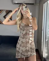 Vestido corto marrón con estampado de flores blancas, escote en V y tirantes finos.