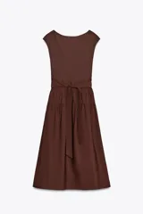 Vestido midi marrón con cuello barco y manga sisa. Presenta un corte a la altura de la cintura con detalle de trabilla y lazo del mismo tejido. Cierre lateral con cremallera oculta.