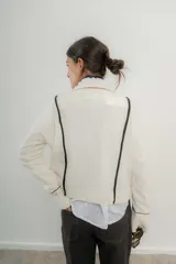 Saco de lana italiano azul con cuello en V, cierre con botones y ribetes en contraste.