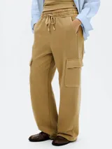 Pantalón cargo color marrón claro, de corte ancho, con bolsillos laterales con solapa y cintura ajustable con cordón.