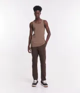 Pantalón de vestir marrón, de corte skinny, con bolsillos laterales y traseros. Se ajusta a la cintura con cinturón de cuero marrón.