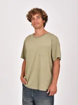 Remera de manga corta color verde oliva, con cuello redondo y un bolsillo frontal en el pecho.