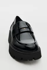 Zapato tipo mocasín negro acharolado con antifaz y suela track.