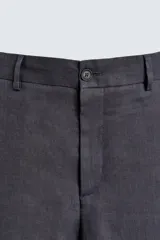 Pantalón de vestir gris oscuro, de corte amplio y largo a la pantorrilla. Confeccionado en lino, con bolsillos laterales y traseros. Cierre frontal con cremallera y botón.