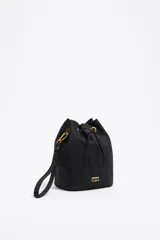 Neceser tipo bucket de nylon color negro con logo de la marca estampado en dorado. Tiene cierre con cordón ajustable y asa de mano.