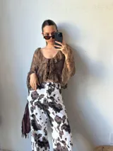Pantalón de jean con estampado animal print de vaca en tonos marrón y blanco, de corte recto.