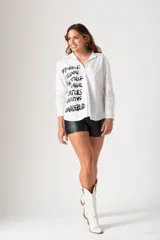 Camisa blanca de mangas largas con cuello alto.
