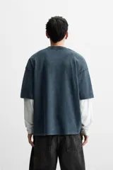 Camiseta azul con efecto lavado, corte holgado, cuello redondo y mangas cortas.