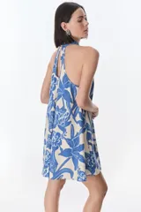 Vestido corto con estampado floral en tonos rojo y beige, cuello halter y corte evasé.