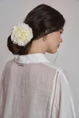Camisa blanca de lino con cuello clásico, cierre frontal con botones y mangas anchas 3/4. Presenta detalles de bordado calado en el frente y puños.