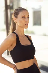 Top deportivo negro con breteles anchos y espalda deportiva.