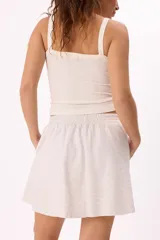 Conjunto deportivo negro compuesto por un buzo con cierre frontal y falda corta. El buzo es de corte holgado, con cuello alto, cierre frontal y mangas largas con puños elásticos. La falda es corta, de corte evasé y cintura elástica.