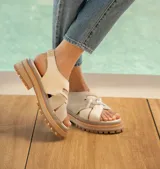 Sandalias de cuero vacuno color marrón, con tiras anchas cruzadas en el empeine, elástico en el talón y doble suela de goma deportiva.