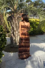 Vestido strapless largo con estampado batik en tonos marrones y beige, entallado al cuerpo y con espalda baja descubierta.