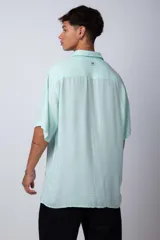 Camisa celeste de manga corta con cuello clásico y calce oversize.