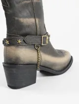 Botas tejanas de caña media color negro con detalles en dorado, hechas de cuero vegano y con correa con hebilla y tachas de estrella.