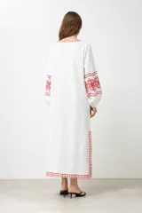 Túnica larga color crudo con bordados rojos en cuello, mangas y ruedo.