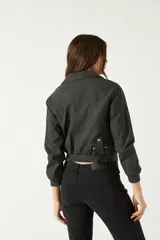 Campera corta color marrón chocolate, con textura tipo gamuza, cuello clásico, cierre frontal asimétrico con cremallera metálica y bolsillos laterales con cremallera.