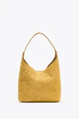 Bolso de hombro amarillo con cuerpo en relieve efecto trenzado, asa de hombro, cartera interior con cierre mediante cremallera metálica, base rígida con tachas y cierre mediante botón imantado.
