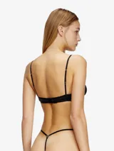 Sujetador tipo bralette negro, con copas triangulares y tirantes finos ajustables. Presenta un pequeño dije metálico en el centro.