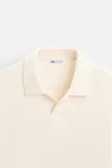 Polo azul marino de manga larga con cuello solapa, abertura frontal y acabado en rib.