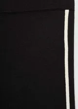 Pantalón largo acampanado de punto fino color negro, con cintura elástica alta y detalle de pipping en contraste blanco en los laterales.
