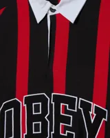 Camiseta tipo polo de manga larga Obey, con rayas verticales rojas y negras, cuello blanco y logo bordado en el pecho.