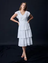Vestido blanco de gasa con capas de la marca Julia Jordan. Tiene escote en V, mangas cortas con volados, corte en la cintura, abertura central en la espalda con cierre invisible y forro interno a tono.