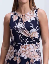 Vestido maxi de seda fría con estampado floral en tonos beige y azul marino, de la marca Sandra Darren. Tiene cuello alto entrelazado con abertura ojal y aplique metálico.