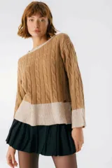 Sweater color camel con tejido de trenzas y terminaciones en color beige.