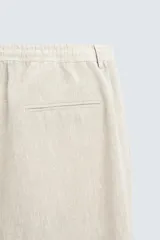 Pantalón de vestir color beige claro, de corte recto, confeccionado en lino.