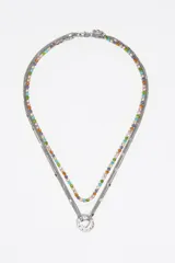 Collar de múltiples cadenas con acabado metálico plateado. Presenta una hilera de cristales multicolores y varias cadenas finas que convergen en un dije circular central con un calado en forma de corazón y la palabra 'LOVE' grabada. Posee cierre de mosquetón.