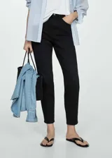 Pantalón de jeans negro de corte mom-fit, tiro alto, cinco bolsillos, trabillas y cierre con cremallera y botón.